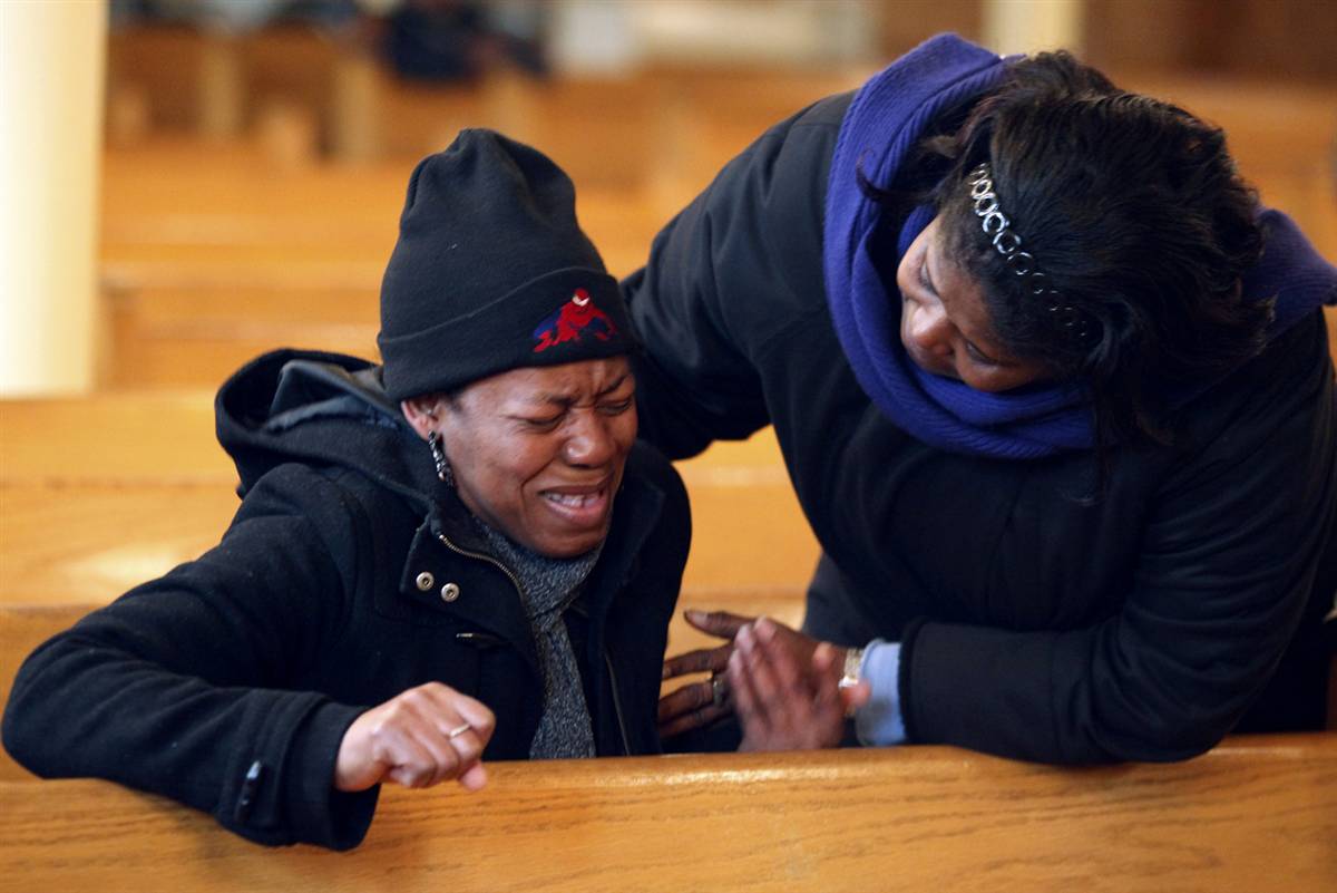 A woman in New York prays for earthquake victims